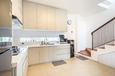 a kitchen with white cabinets and a staircase at Vinca Villa Bali in Kerobokan