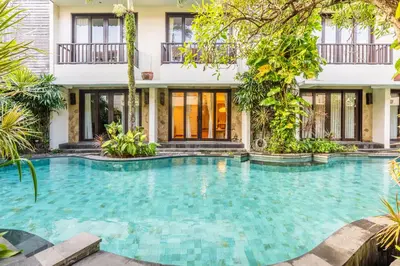 a swimming pool in front of a house at IRMAS Villa Bali in Seminyak