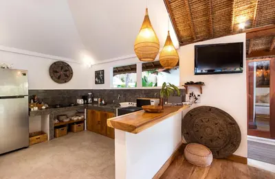 a kitchen with a counter and a refrigerator at Villa Waterlily by Villa Finder in Seminyak