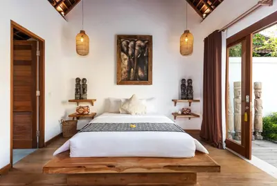 a bedroom with a bed with a wooden platform at Villa Waterlily by Villa Finder in Seminyak