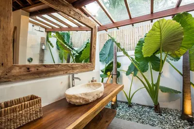 a bathroom with a sink and a large plant at Villa Waterlily by Villa Finder in Seminyak