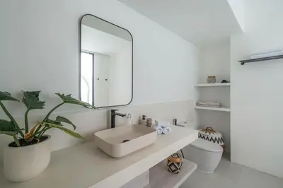 a white bathroom with a sink and a mirror at Villa Jenna - Exquisite 3BR Villa Close to Batu Belig Beach in Canggu