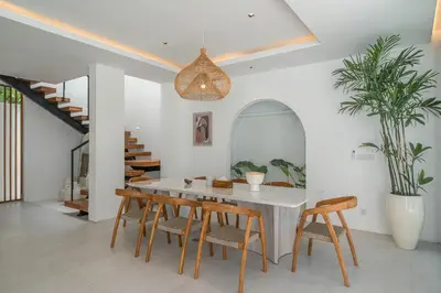 a dining room with a white table and chairs at Villa Jenna - Exquisite 3BR Villa Close to Batu Belig Beach in Canggu