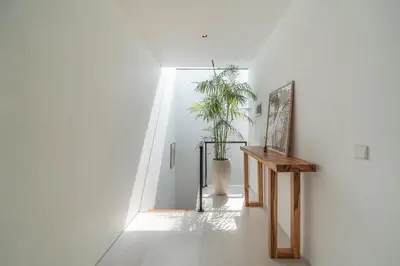 a hallway with a potted plant in a white wall at Villa Jenna - Exquisite 3BR Villa Close to Batu Belig Beach in Canggu