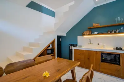 a kitchen with a wooden table and a staircase at NEW! Villa Sony 1 - 3BR Villa next to Legian Beach in Seminyak