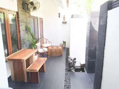 a patio with a wooden bench and a table at Salt Hideaway - 2 BR apartment, central Seminyak in Seminyak