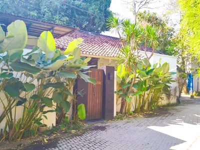 a house with a wooden gate next to a street at Salt Hideaway - 2 BR apartment, central Seminyak in Seminyak