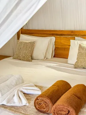 a bed with white sheets and towels on it at Villa Blubambu in Seminyak