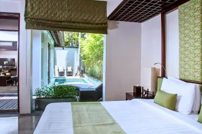 a bedroom with a bed and a swimming pool at Liam 1 BR Bamboo Private Pool Villa JU63 in Seminyak