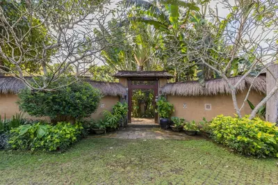 an entrance to a house with a gate and trees at Bali Villa Home in Seminyak