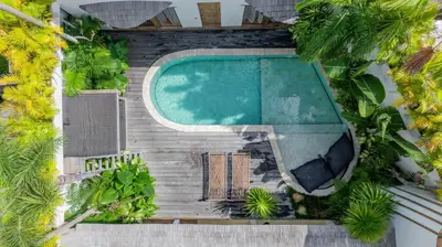 an overhead view of a swimming pool with palm trees at Villa Elita - Modern Stylish 4BR Villa with Rooftop Lounge, 12 Minutes to the Beach in Kerobokan