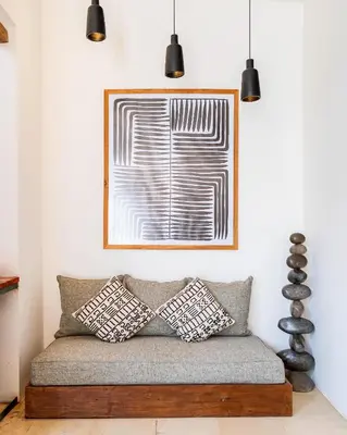 a living room with a couch with a picture on the wall at Villa Elita - Modern Stylish 4BR Villa with Rooftop Lounge, 12 Minutes to the Beach in Kerobokan