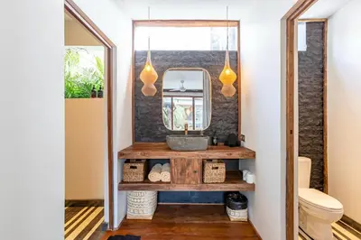 a bathroom with a sink and a mirror at Villa Elita - Modern Stylish 4BR Villa with Rooftop Lounge, 12 Minutes to the Beach in Kerobokan