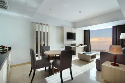 a living room with a table and chairs in a room at Sovereign Bali Hotel in Kuta