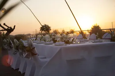 a group of tables with white chairs and wine glasses at Sovereign Bali Hotel in Kuta