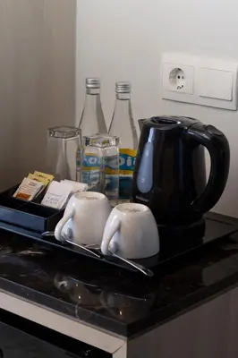 a kitchen counter with two cups and a coffee maker at Sovereign Bali Hotel in Kuta