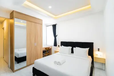 a bedroom with a white bed and a mirror at Alyxia 1 Bedroom Apartment in Central Seminyak in Seminyak