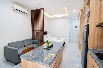 a kitchen and living room with a couch and a table at Alyxia 1 Bedroom Apartment in Central Seminyak in Seminyak