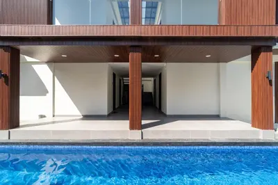 a house with a swimming pool next to a building at Alyxia 1 Bedroom Apartment in Central Seminyak in Seminyak