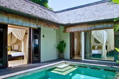 a villa with a swimming pool and a bedroom at Dilana 2 BR Bamboo Villas JU66 in Seminyak