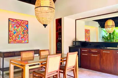 a dining room with a wooden table and chairs at Dilana 2 BR Bamboo Villas JU66 in Seminyak