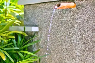 a water hose coming out of a stone wall at Dilana 2 BR Bamboo Villas JU66 in Seminyak