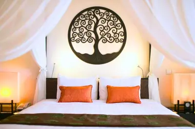 a bedroom with a bed with a tree on the wall at Nisara 2 BR Garden Pool Villas JU67 in Seminyak