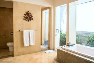 a bathroom with a tub and a toilet and a window at Nisara 2 BR Garden Pool Villas JU67 in Seminyak