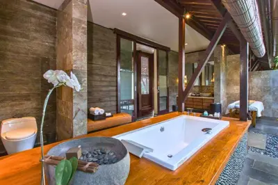 a large bathroom with a tub and a bedroom at Neada 4 BR Grand Pool Villa JU68 in Seminyak
