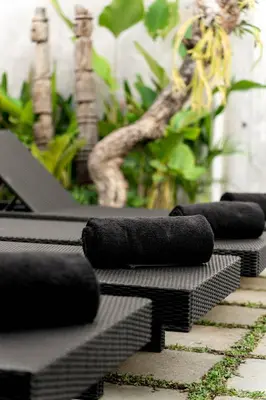 a row of black cushions sitting on a patio at Villa Under the Sun - Seminyak in Seminyak