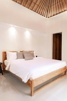 a bedroom with a large bed with white sheets at Villa Under the Sun - Seminyak in Seminyak