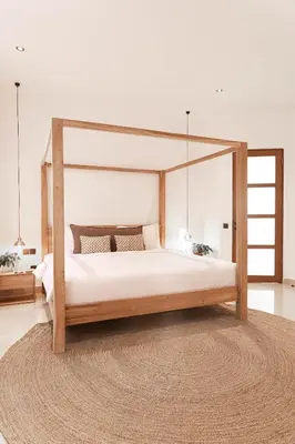 a bedroom with a wooden canopy bed with a rug at Villa Under the Sun - Seminyak in Seminyak