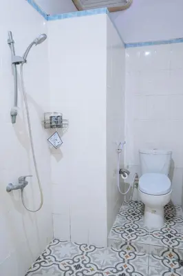 a white bathroom with a toilet and a shower at MIMU C-O Living in Kerobokan