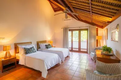a bedroom with two beds and a table and chairs at Villa Pande Sanur Beach Side in Sanur