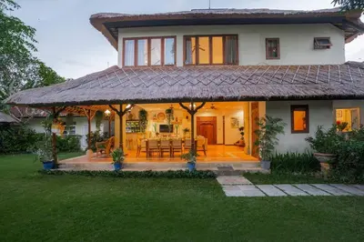 a house with a large porch with a dining room at Villa Pande Sanur Beach Side in Sanur