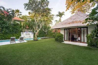 a house with a yard with a swimming pool at Villa Pande Sanur Beach Side in Sanur