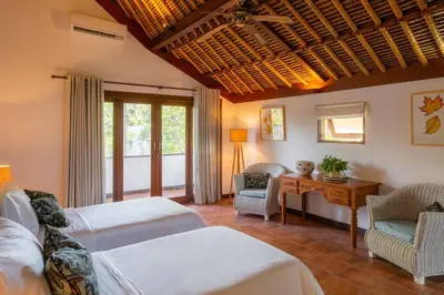 a bedroom with two beds and a table and chairs at Villa Pande Sanur Beach Side in Sanur