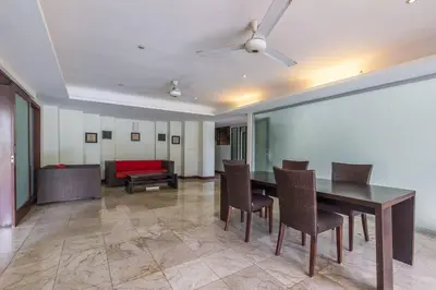 a dining room with a table and chairs and a couch at Quiet Central Seminyak 2bd 2 bath and walk to eat st in Seminyak