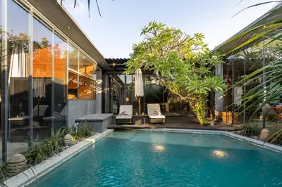 an indoor pool in a house with glass walls at Luxury Industrial Villa with Sauna and Highend Amenities in Seminyak