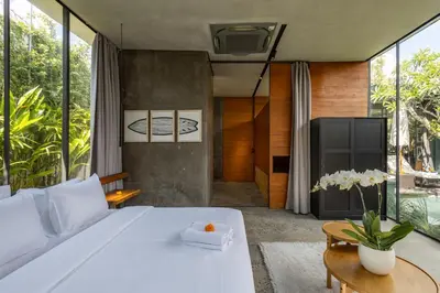 a bedroom with a large white bed and some windows at Luxury Industrial Villa with Sauna and Highend Amenities in Seminyak
