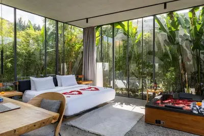 a bedroom with a bed and a desk and windows at Luxury Industrial Villa with Sauna and Highend Amenities in Seminyak