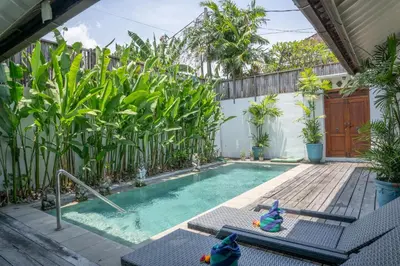 a swimming pool in a backyard with plants at Villa Catalina Seminyak in Seminyak