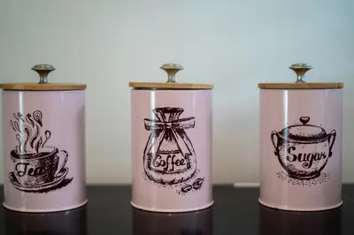 a group of four coffee cans with drawings on them at Villa Catalina Seminyak in Seminyak