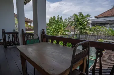 a wooden table on the porch of a house at Villa Catalina Seminyak in Seminyak