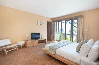 a bedroom with a large bed and a television at Villa Ewa 1 in Seminyak