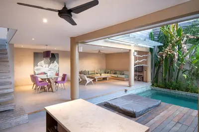 a house with a swimming pool and a living room at Villa Ewa 1 in Seminyak
