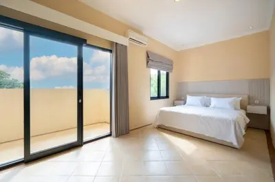 a bedroom with a bed and large sliding glass doors at Villa Uma Sari c9 in Seminyak