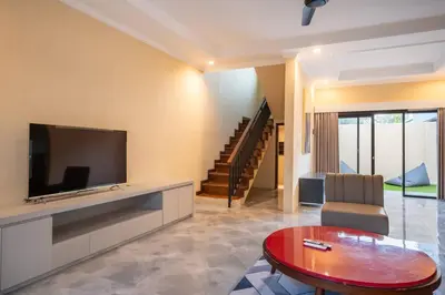 a living room with a flat screen tv and a table at Villa Uma Sari c9 in Seminyak