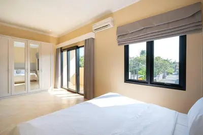 a bedroom with a white bed and a window at Villa Uma Sari c9 in Seminyak