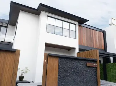 a white house with a wooden fence in front of it at Modern Palace in Seminyak - Qmoya Villa in Seminyak